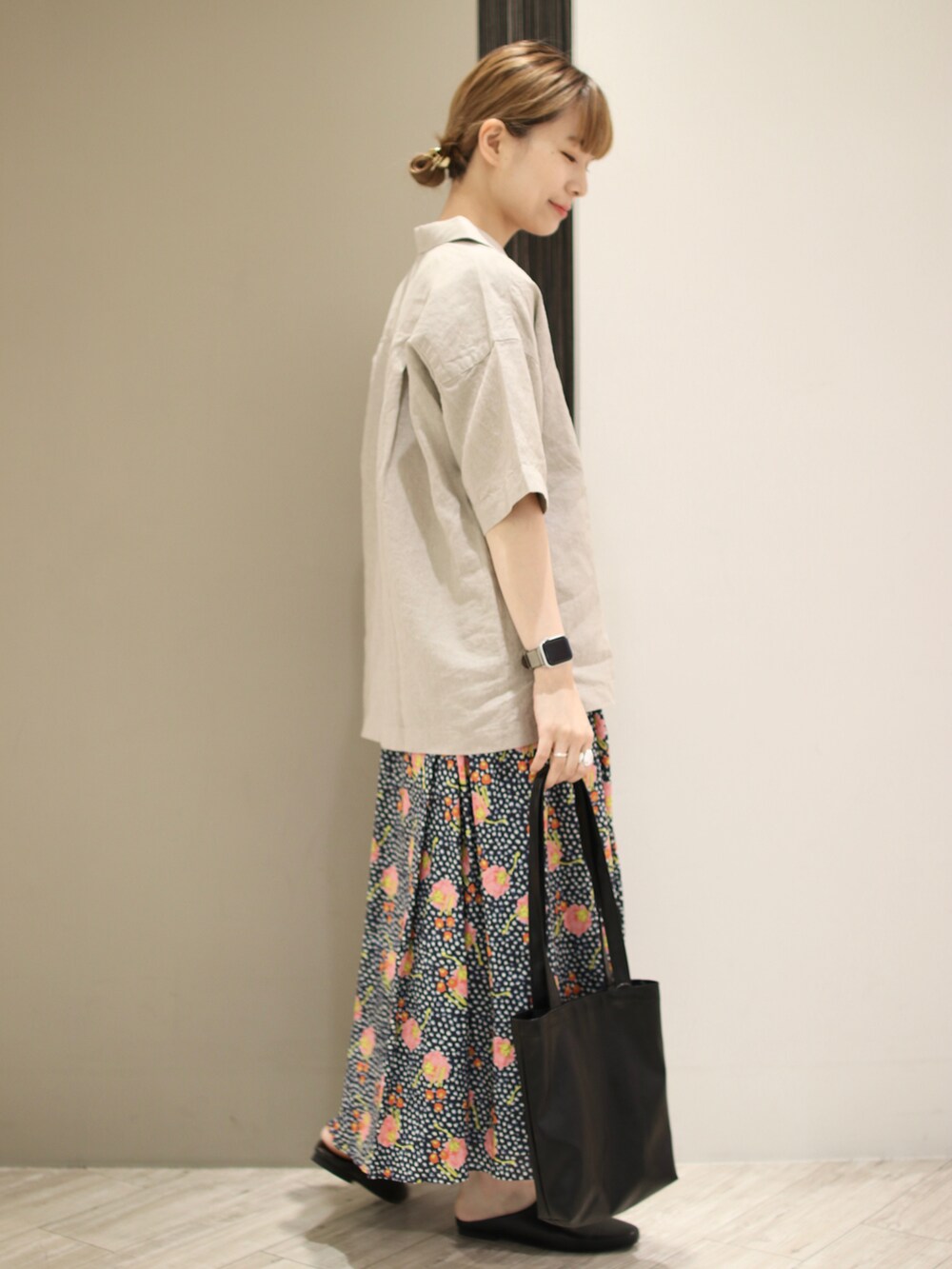 ベージュ系のTシャツ/カットソー、ブルー系のスカート、ブラック系のトートバッグを着用したレディースの夏コーディネートの2枚目の写真