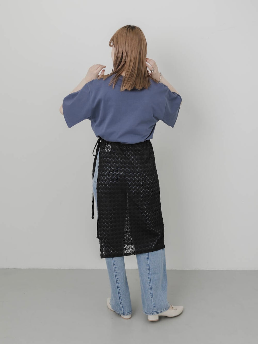 ブルー系のデニムパンツ、ホワイト系のパンプス、ブラック系のスカートを着用したレディースの夏コーディネートの3枚目の写真