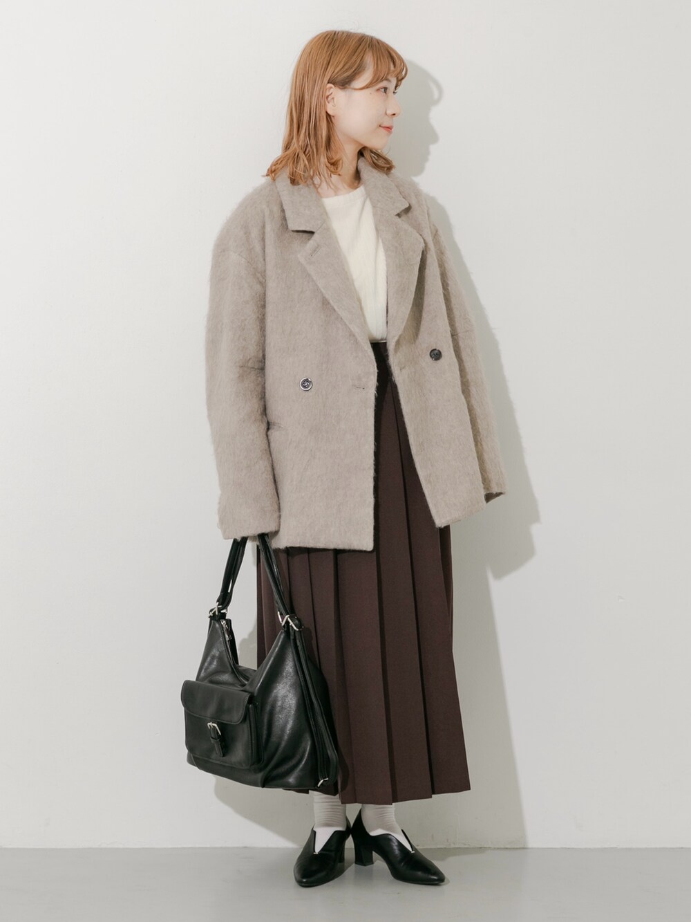 ブラウン系のスカート、ブラウン系のその他アウター、ホワイト系のTシャツ/カットソーを着用したレディースの秋コーディネートの2枚目の写真