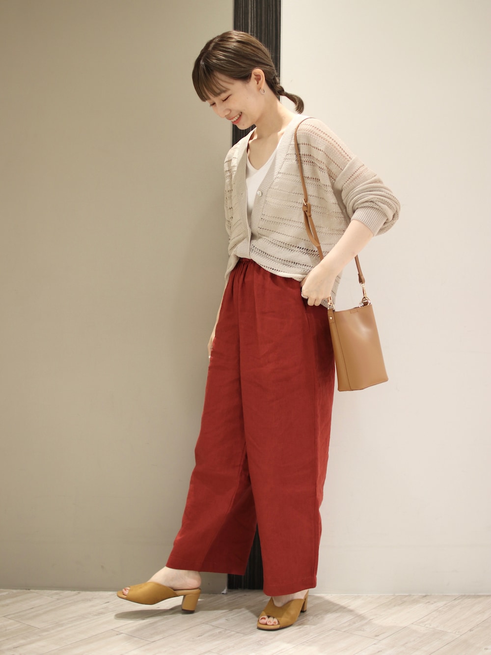 ベージュ系のカーディガン/ボレロ、ホワイト系のタンクトップ、ブラウン系のその他パンツを着用したレディースの夏コーディネートの2枚目の写真