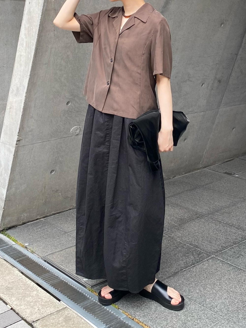 ブラック系のスカート、ブラウン系のシャツ/ブラウス、ブラック系のサンダルを着用したレディースの夏コーディネートの8枚目の写真