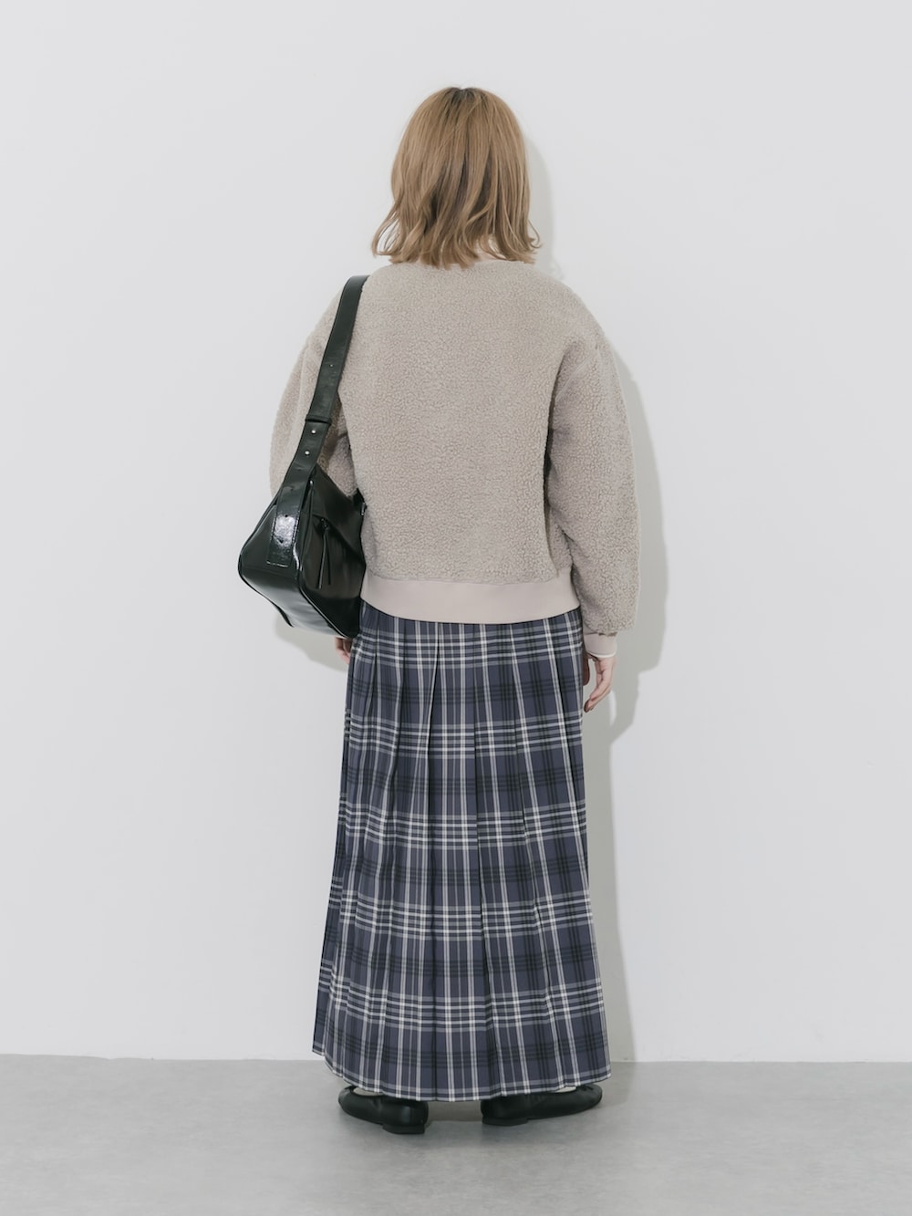 グレー系のスカート、ベージュ系のカーディガン/ボレロ、ブラック系のショルダーバッグを着用したレディースの秋コーディネートの6枚目の写真