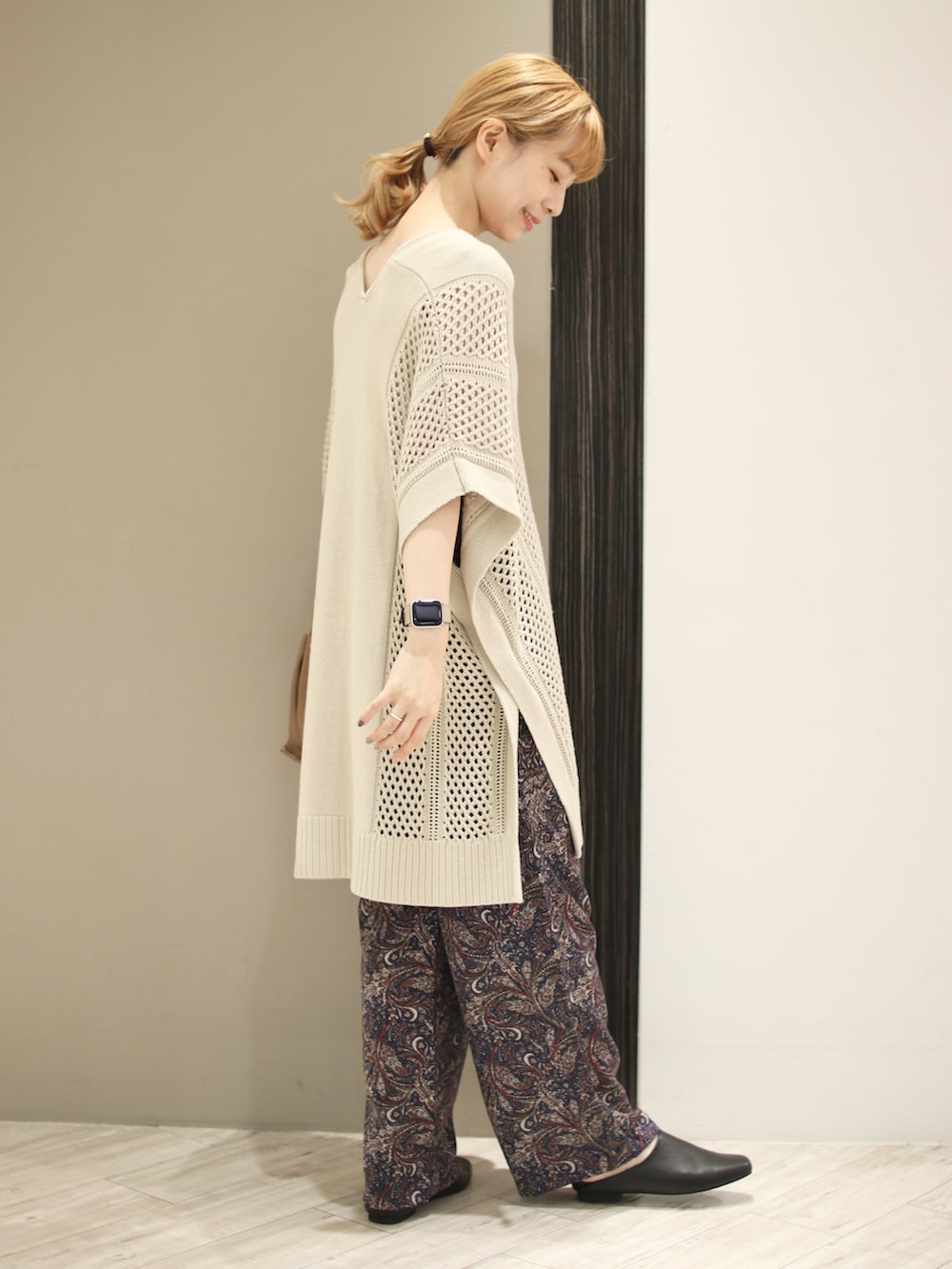 ブルー系のその他パンツ、ベージュ系のニット/セーター、ホワイト系のタンクトップを着用したレディースの秋コーディネートの3枚目の写真