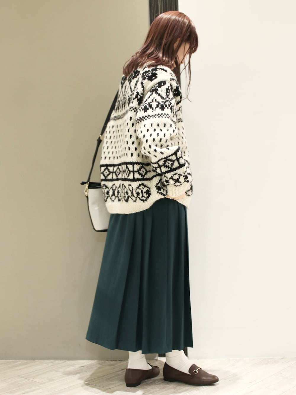 ホワイト系のカーディガン/ボレロ、グリーン系のワンピース、ブラック系のショルダーバッグを着用したレディースの冬コーディネートの3枚目の写真