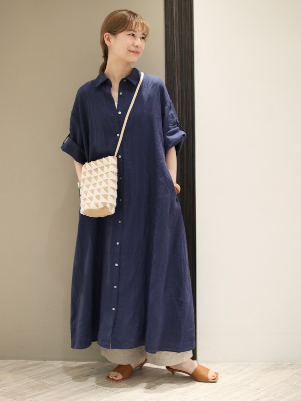 ホワイト系のショルダーバッグ、ブルー系のワンピース、イエロー系のサンダルを着用したレディースの春コーディネートの2枚目の写真