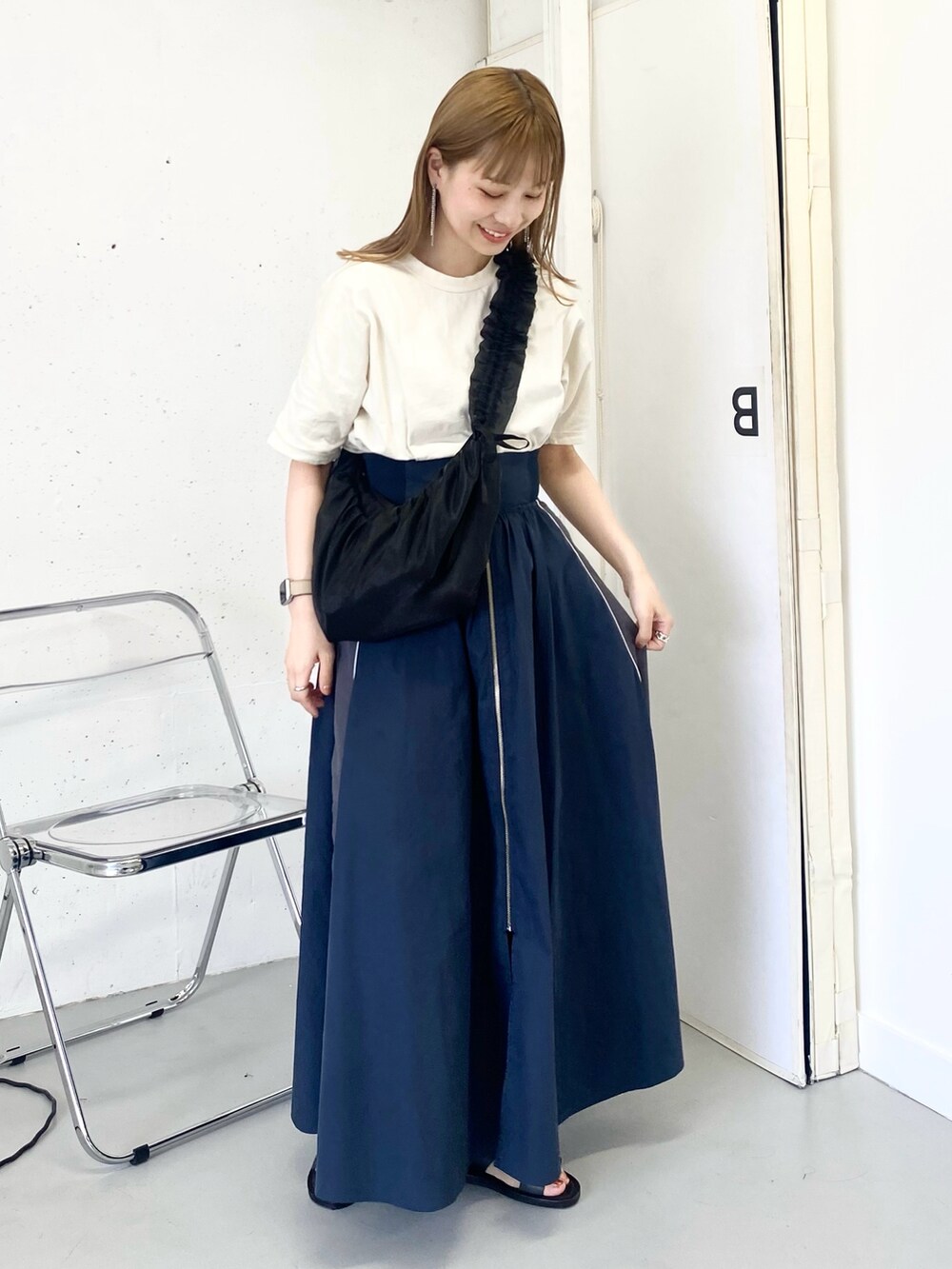 ブラック系のショルダーバッグ、ブラック系のサンダル、ブルー系のスカートを着用したレディースの夏コーディネートの2枚目の写真