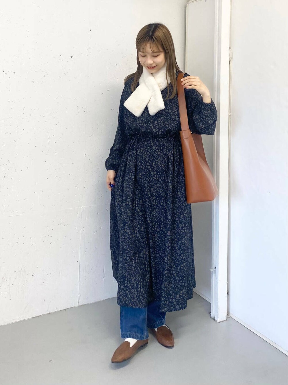 ブラウン系のスリッポン、ブルー系のデニムパンツ、ブラウン系のトートバッグを着用したレディースの秋コーディネートの8枚目の写真