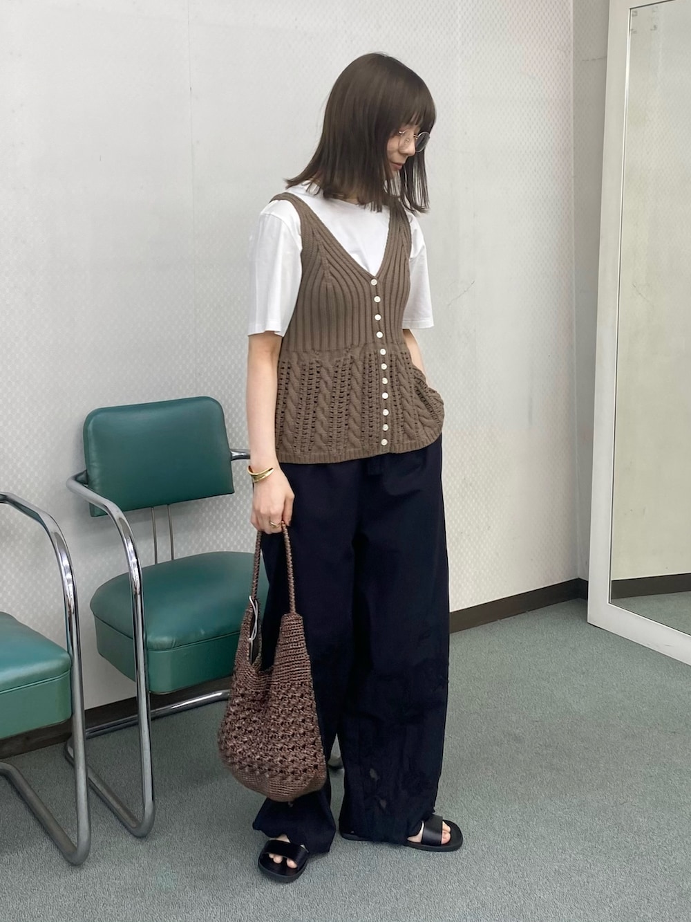 ベージュ系のベスト、ホワイト系のTシャツ/カットソー、ブラック系のその他パンツを着用したレディースの春コーディネートの3枚目の写真