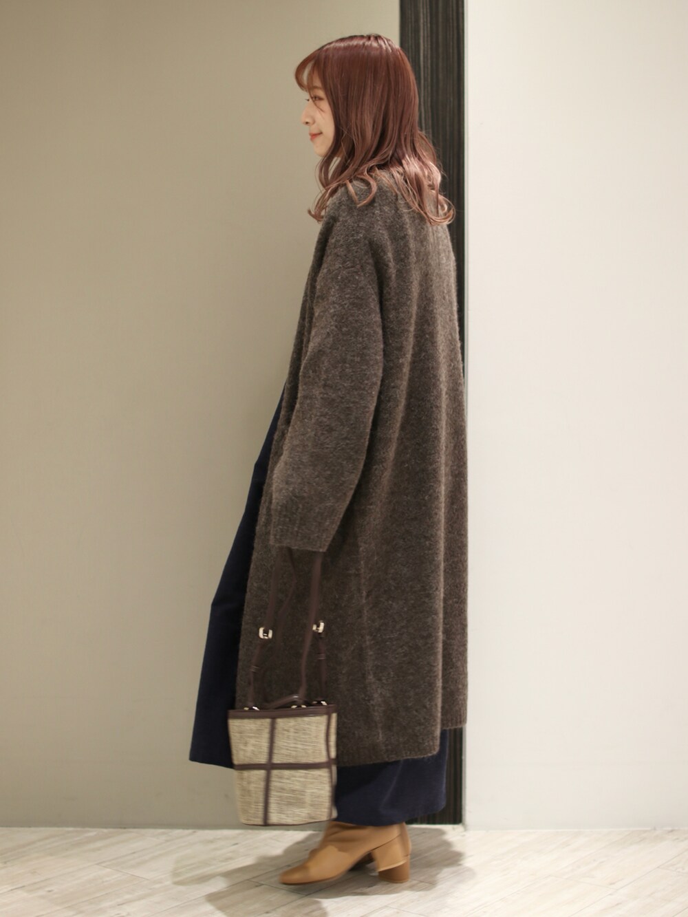 ブラウン系のショルダーバッグ、ブルー系のワンピース、ブラウン系のカーディガン/ボレロを着用したレディースの冬コーディネートの3枚目の写真