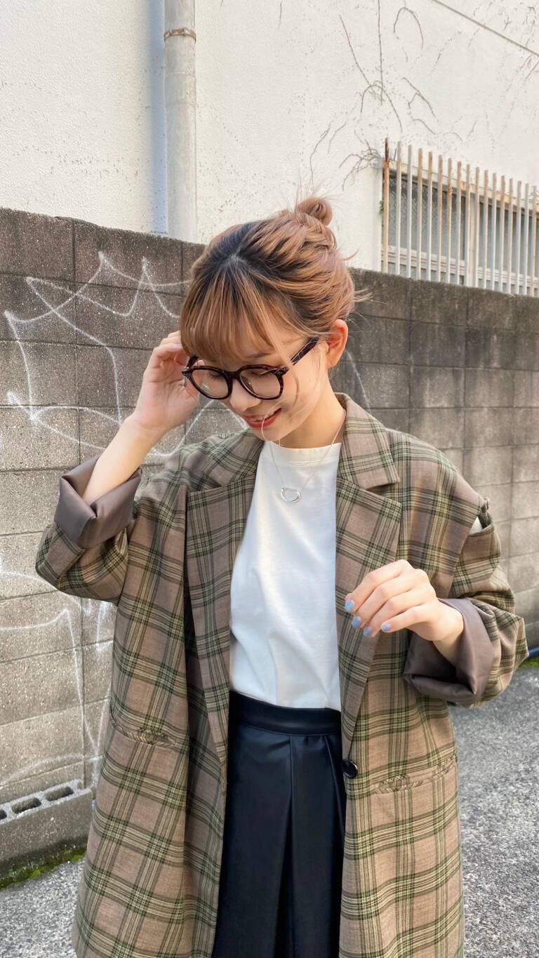 グリーン系のテーラードジャケット、ブラック系のブーツ、ブラック系のスカートを着用したレディースの秋コーディネートの3枚目の写真