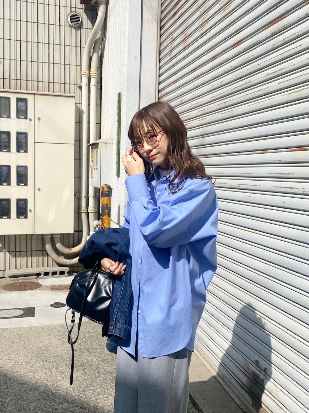 グレー系のその他パンツ、ブルー系のシャツ/ブラウス、ブラック系のショルダーバッグを着用したレディースの春コーディネートの3枚目の写真