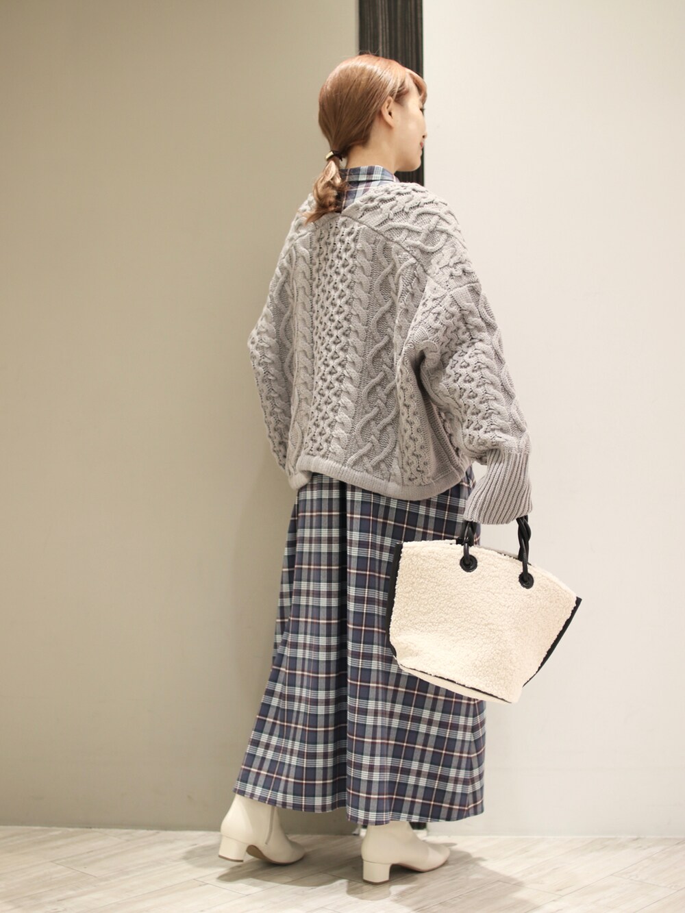 ホワイト系のハンドバッグ、グレー系のワンピース、グレー系のニット/セーターを着用したレディースの秋コーディネートの4枚目の写真