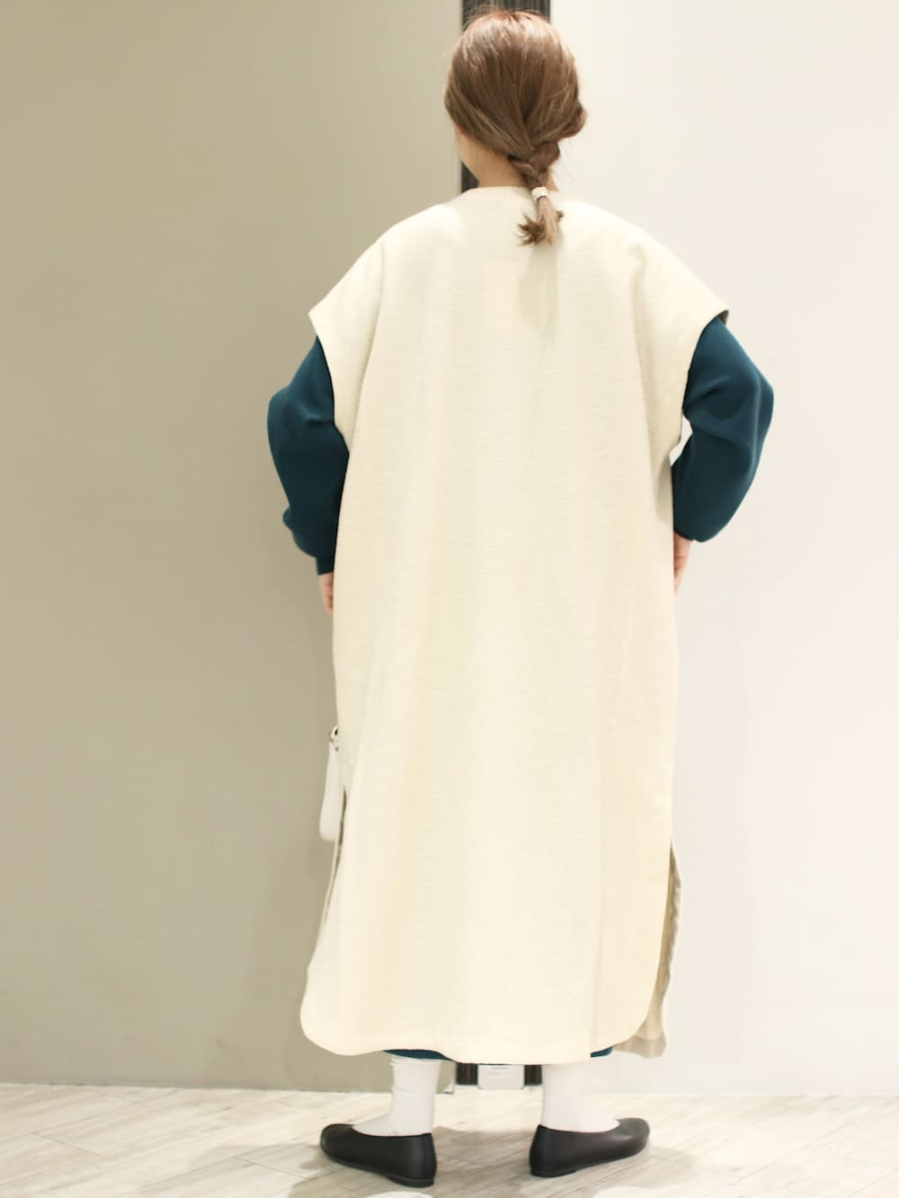 ブラック系のパンプス、ホワイト系のワンピース、ベージュ系のショルダーバッグを着用したレディースの冬コーディネートの4枚目の写真