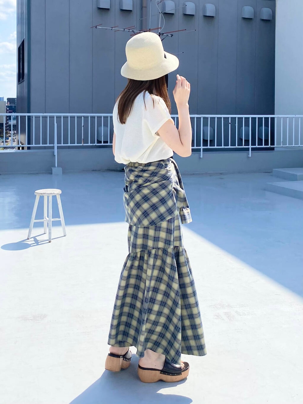 ベージュ系のスカート、ホワイト系のTシャツ/カットソー、ブラウン系のサンダルを着用したレディースの春コーディネートの3枚目の写真