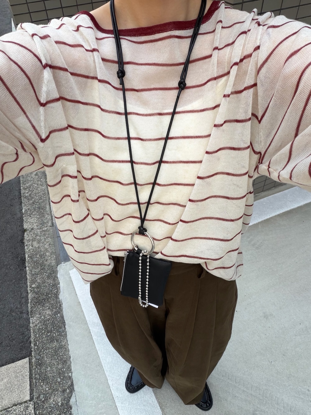 ブラウン系のその他パンツ、ベージュ系のニット/セーター、ブラック系のローファーを着用したレディースの秋コーディネートの6枚目の写真