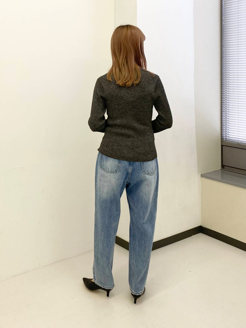 ブルー系のデニムパンツ、ブラック系のキャミソール、ブラック系のカーディガン/ボレロを着用したレディースの秋コーディネートの4枚目の写真