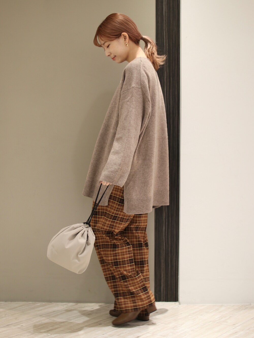 ブラウン系のニット/セーター、ブラウン系のその他パンツ、ベージュ系のショルダーバッグを着用したレディースの秋コーディネートの2枚目の写真