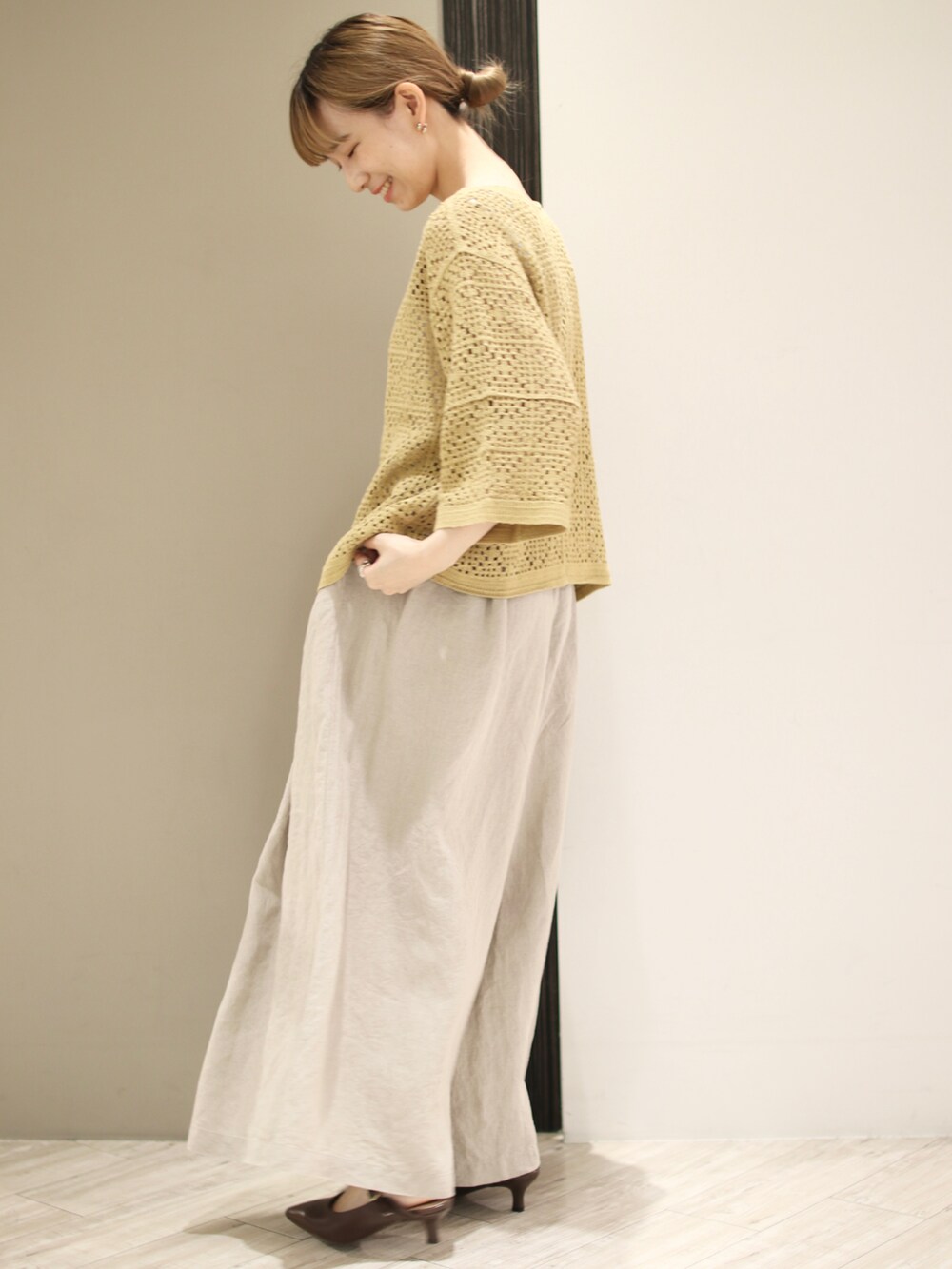 ホワイト系のタンクトップ、イエロー系のカーディガン/ボレロ、ベージュ系のその他パンツを着用したレディースの夏コーディネートの2枚目の写真