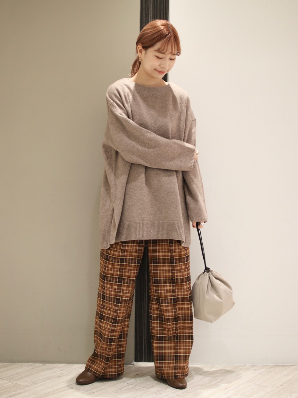 ブラウン系のニット/セーター、ブラウン系のその他パンツ、ベージュ系のショルダーバッグを着用したレディースの秋コーディネートの4枚目の写真