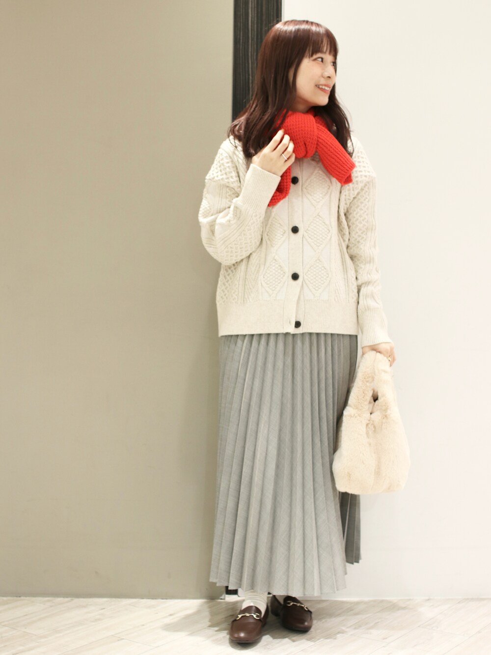 ホワイト系のカーディガン/ボレロ、ホワイト系のハンドバッグ、ブラウン系のローファーを着用したレディースの冬コーディネートの3枚目の写真