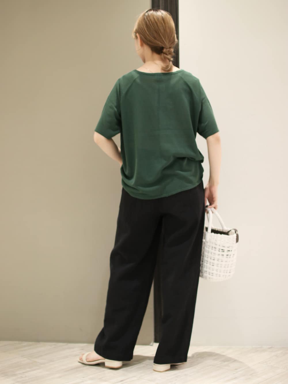 ホワイト系のかごバッグ、ブラック系のその他パンツ、グリーン系のTシャツ/カットソーを着用したレディースの夏コーディネートの3枚目の写真