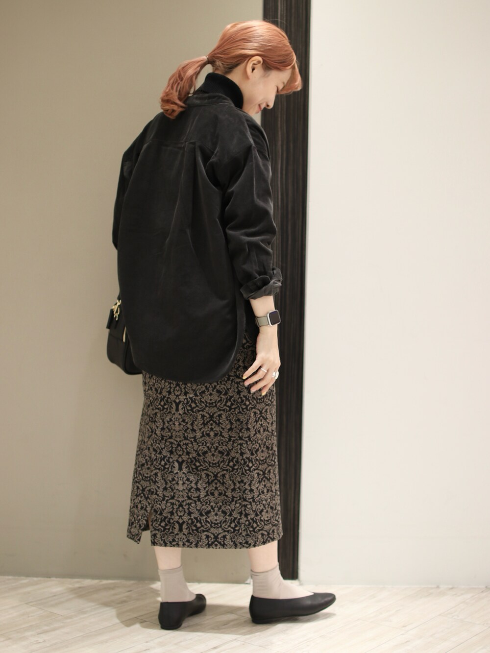 ブラック系のパンプス、ブラック系のショルダーバッグ、ブラック系のスカートを着用したレディースの秋コーディネートの4枚目の写真