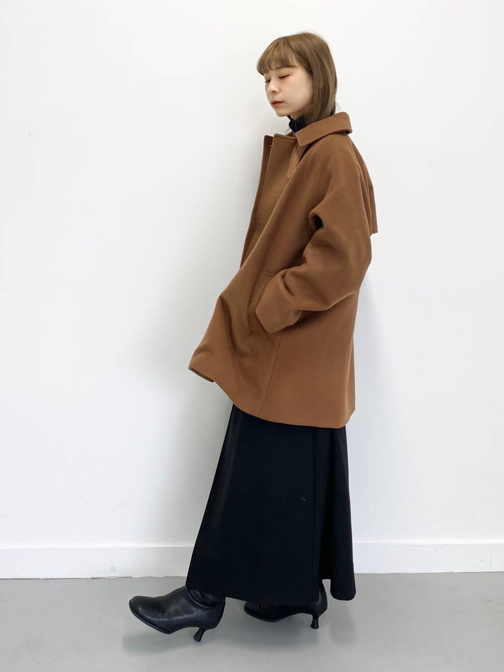 ブラック系のショルダーバッグ、ブラック系のブーツ、ブラック系のワンピースを着用したレディースの冬コーディネートの5枚目の写真