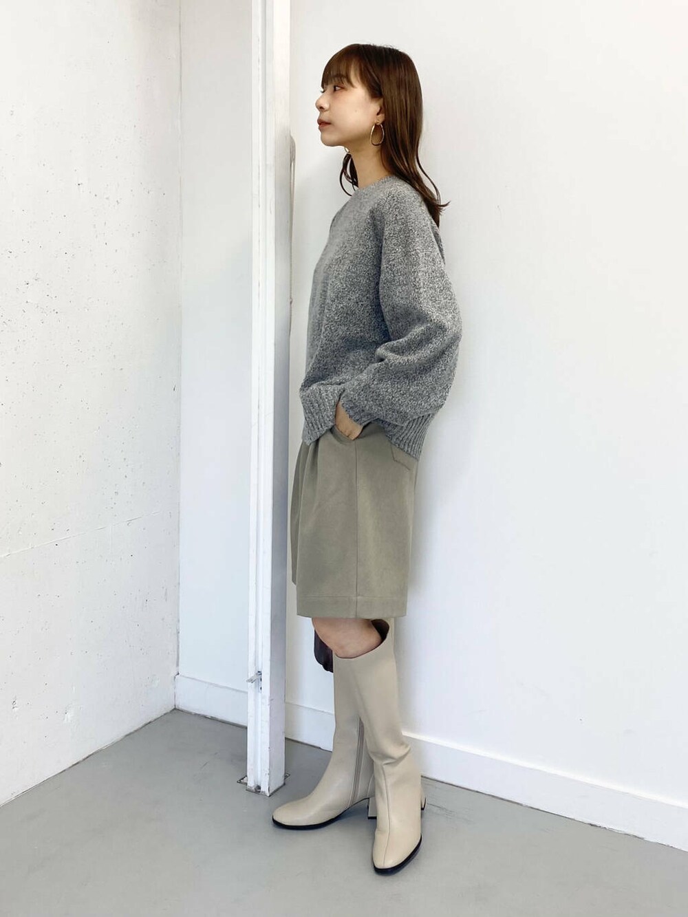 グレー系のニット/セーター、ベージュ系のその他パンツ、ホワイト系のブーツを着用したレディースの冬コーディネートの2枚目の写真