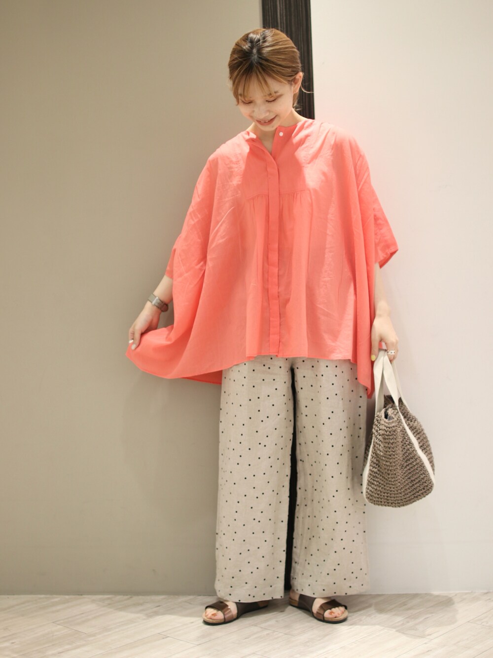 ピンク系のシャツ/ブラウス、ベージュ系のその他パンツ、グレー系のトートバッグを着用したレディースの夏コーディネートの2枚目の写真