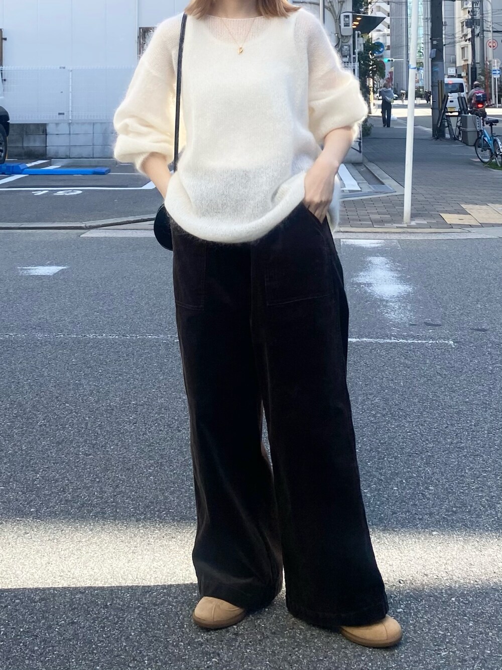 グレー系のその他パンツ、ホワイト系のニット/セーター、ベージュ系のスニーカーを着用したレディースの秋コーディネートの2枚目の写真