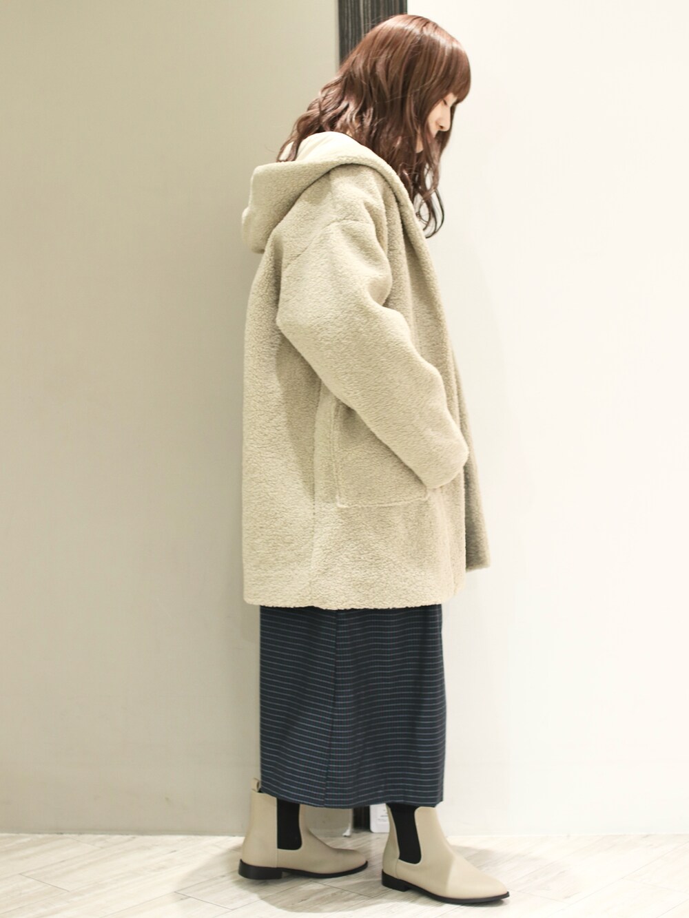 ブルー系のワンピース、ベージュ系のその他アウター、ベージュ系のブーツを着用したレディースの冬コーディネートの4枚目の写真