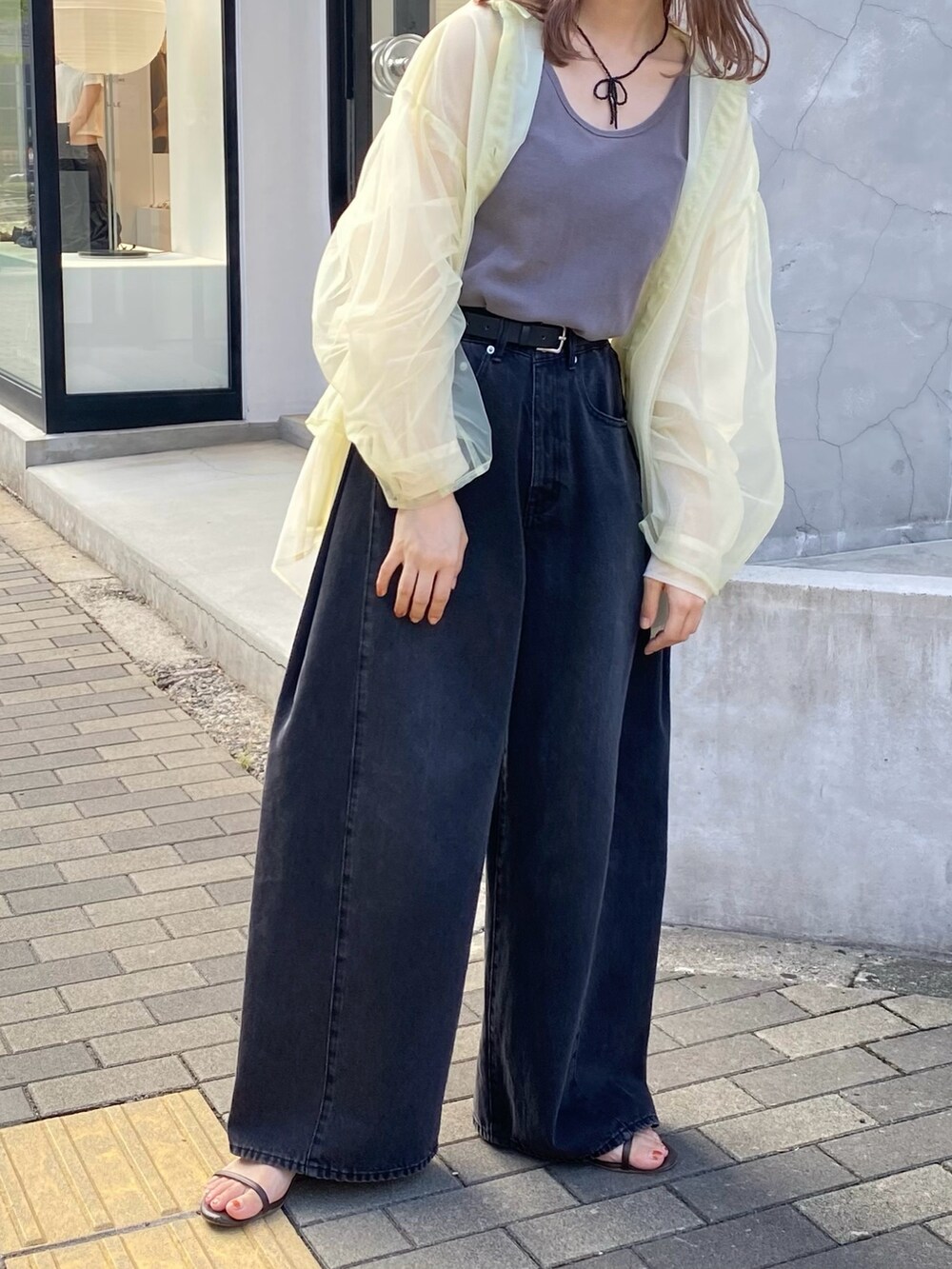 グレー系のタンクトップ、グリーン系のシャツ/ブラウス、ブラック系のデニムパンツを着用したレディースの夏コーディネートの5枚目の写真