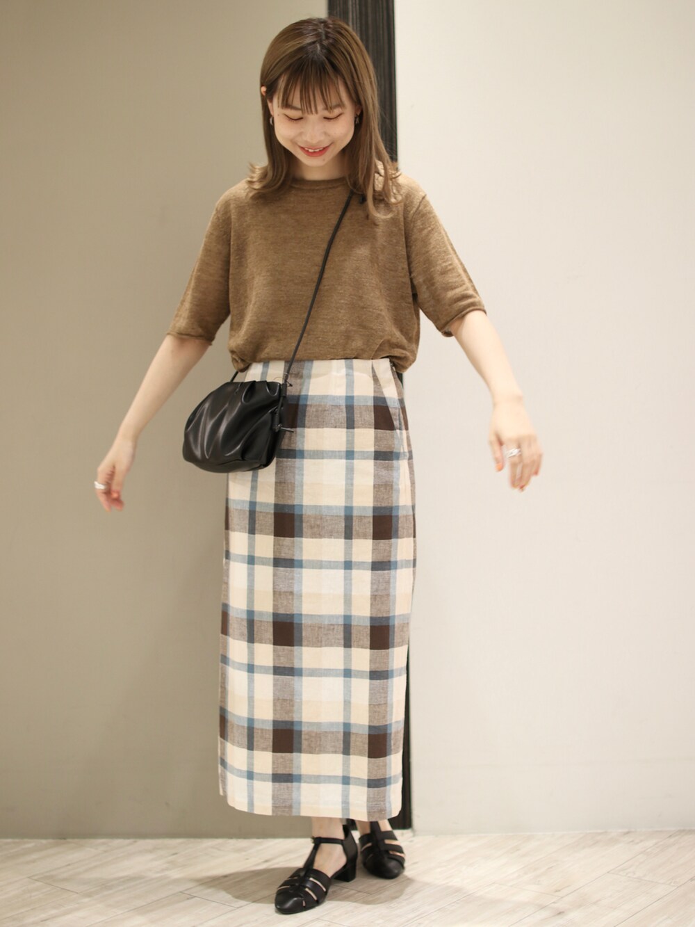 ブラック系のサンダル、ブラウン系のTシャツ/カットソー、ブルー系のスカートを着用したレディースの夏コーディネートの2枚目の写真