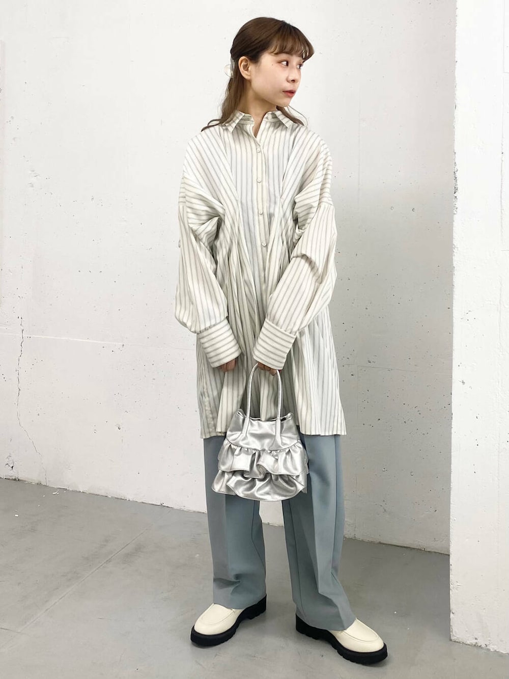 ブルー系のその他パンツ、ホワイト系のローファー、シルバー系のハンドバッグを着用したレディースの春コーディネートの3枚目の写真