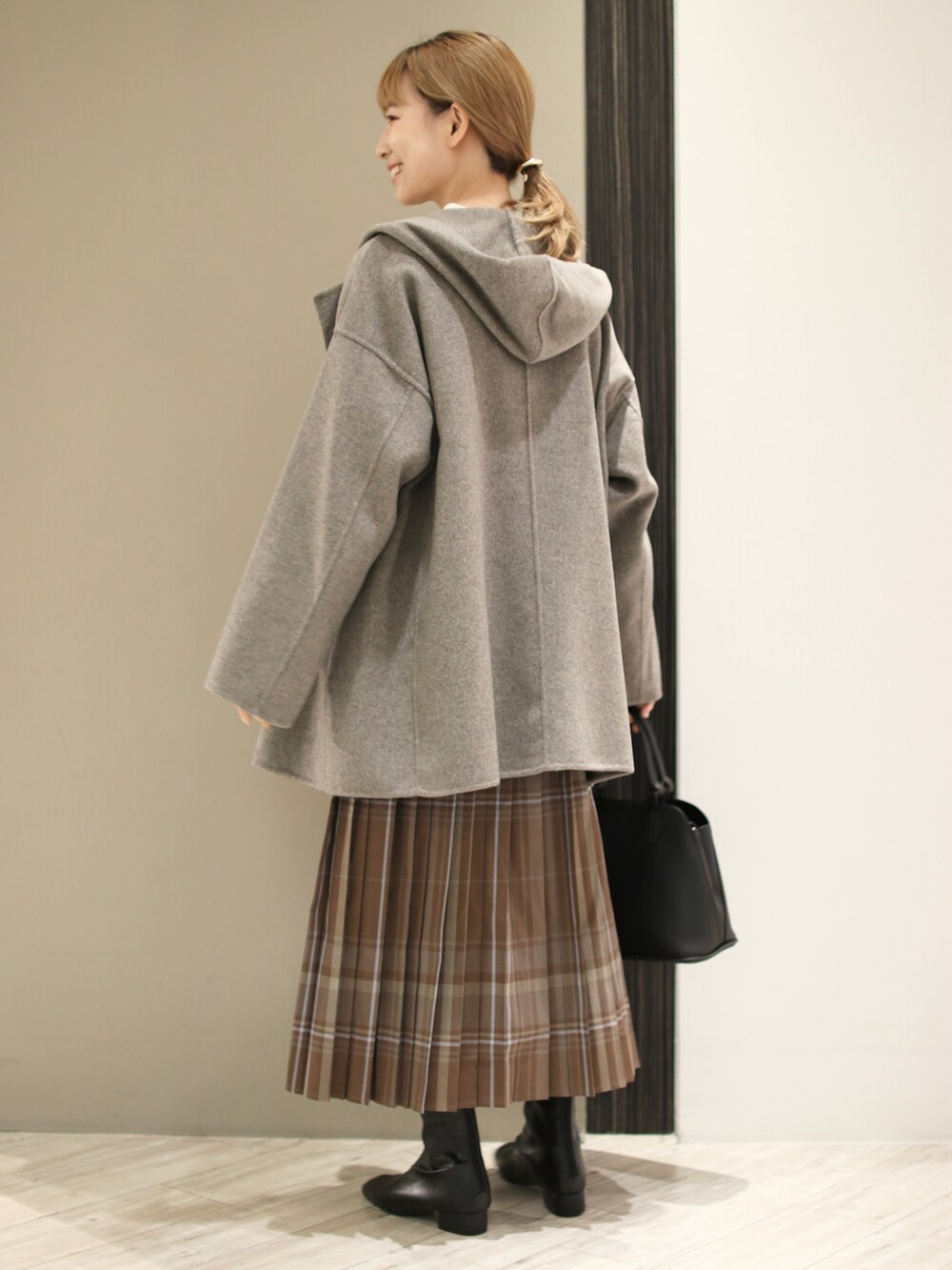 ホワイト系のニット/セーター、グレー系のその他アウター、ブラック系のハンドバッグを着用したレディースの秋コーディネートの3枚目の写真