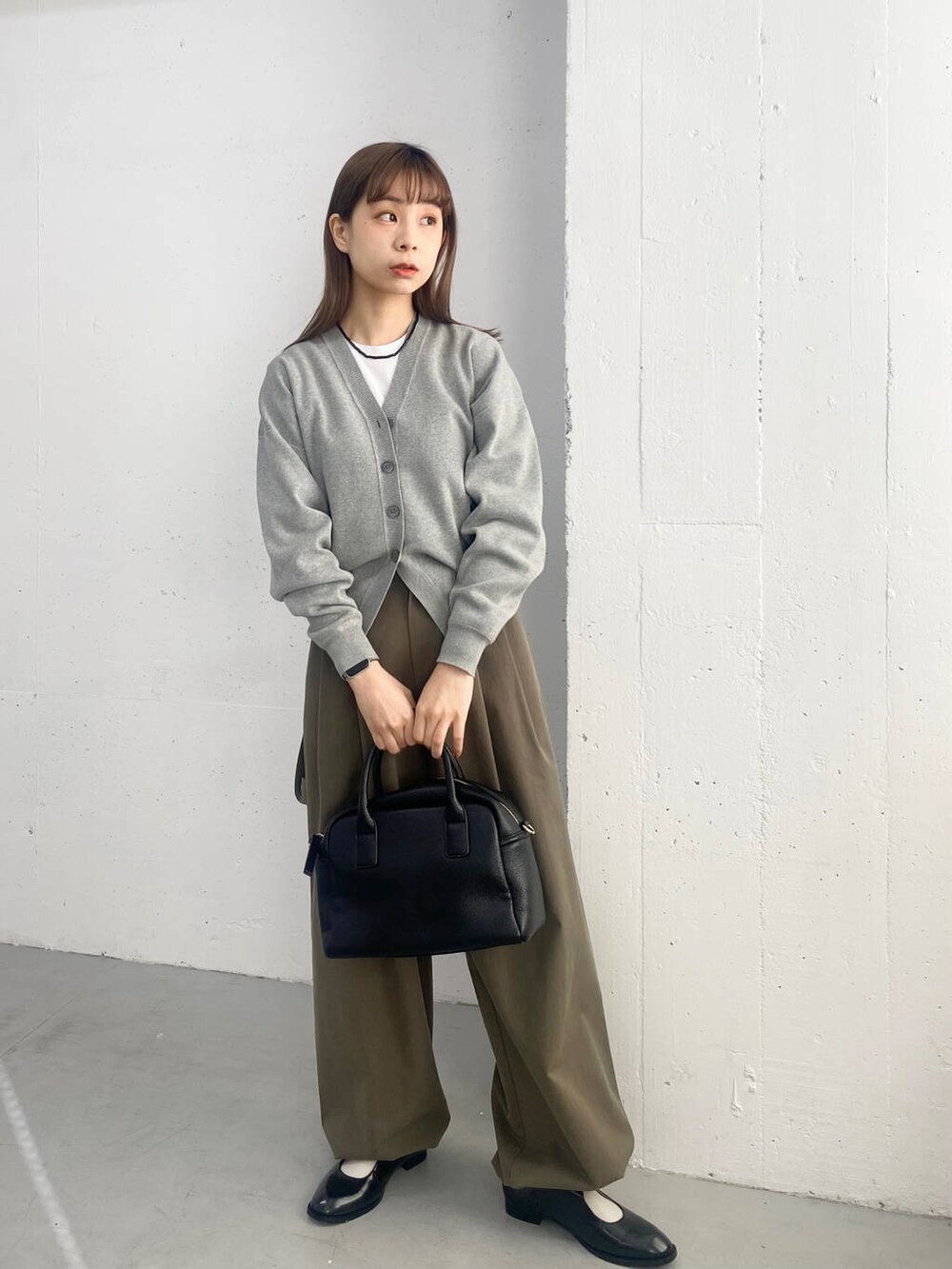 ブラック系のボストンバッグ、ブラック系のローファー、グレー系のカーディガン/ボレロを着用したレディースの春コーディネートの5枚目の写真