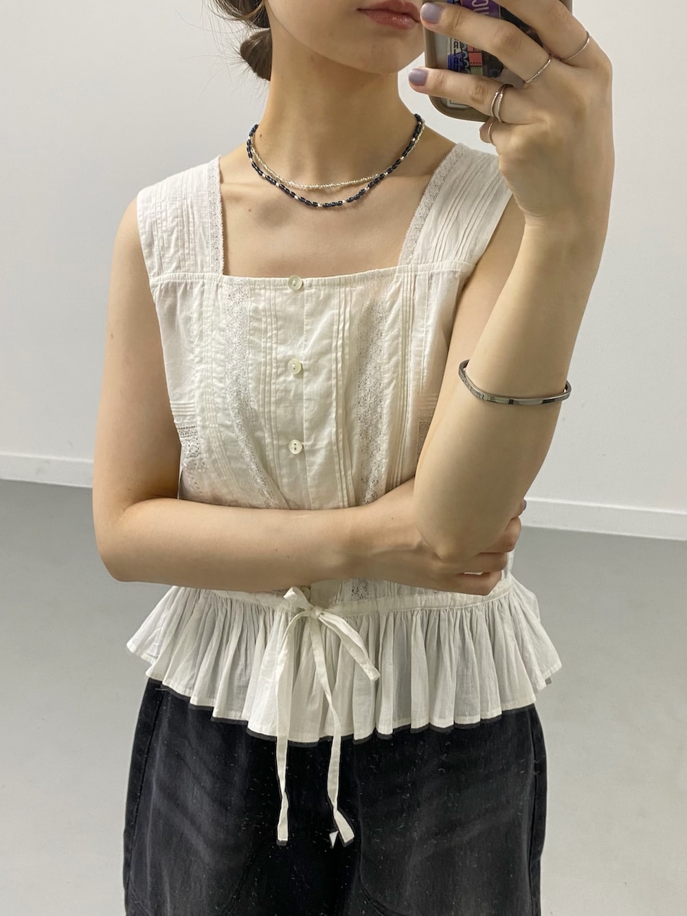 ホワイト系のシャツ/ブラウス、ブラック系のデニムパンツ、ブラック系のサンダルを着用したレディースの夏コーディネートの3枚目の写真