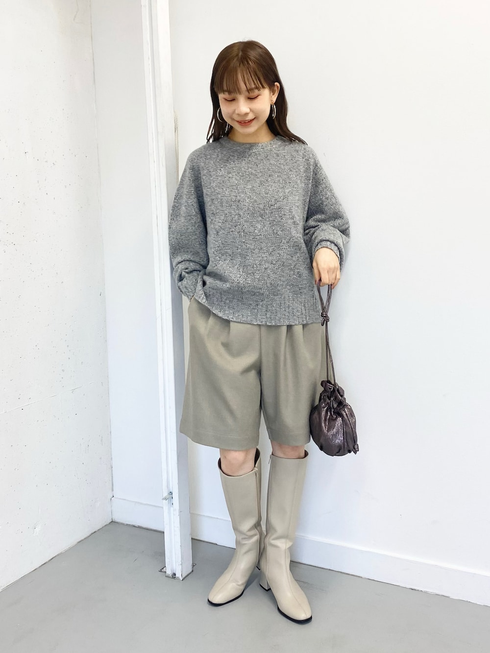 グレー系のニット/セーター、ベージュ系のその他パンツ、ホワイト系のブーツを着用したレディースの冬コーディネートの2枚目の写真