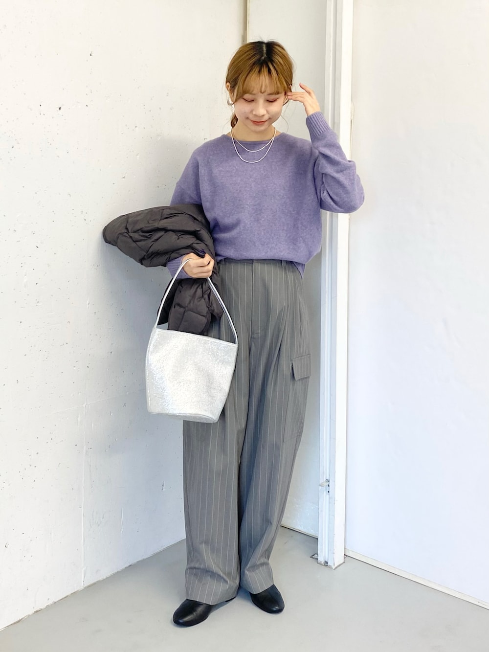 グレー系のその他パンツ、ブラック系のブーツ、シルバー系のハンドバッグを着用したレディースの冬コーディネートの3枚目の写真