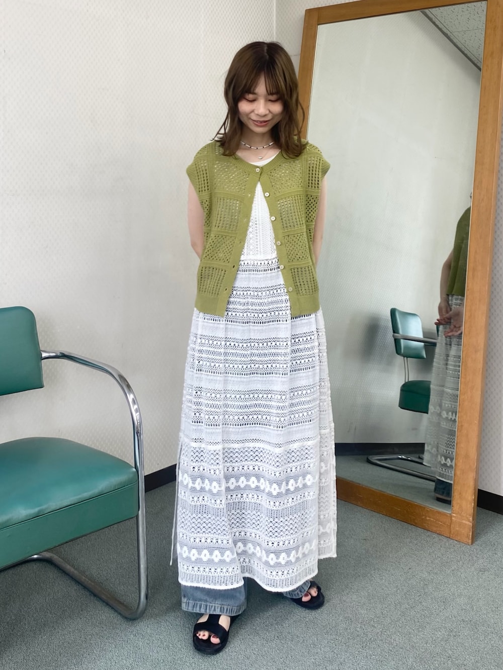 グリーン系のニット/セーター、ホワイト系のワンピース、ホワイト系のネックレスを着用したレディースの夏コーディネートの2枚目の写真