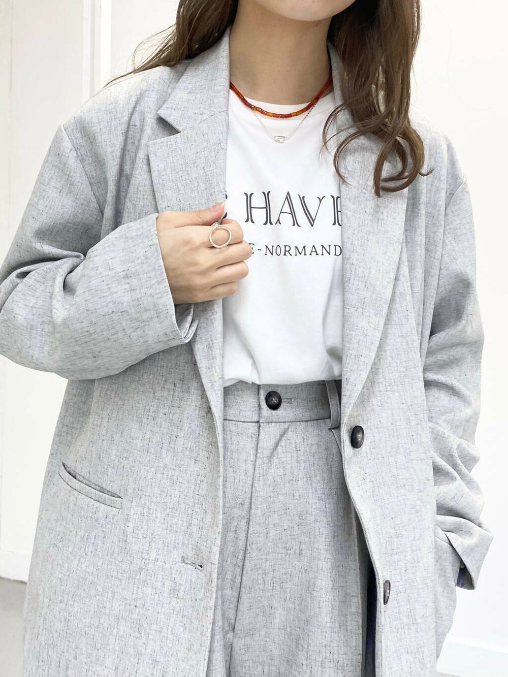 ブラック系のローファー、グレー系のその他パンツ、レッド系のネックレスを着用したレディースの春コーディネートの3枚目の写真