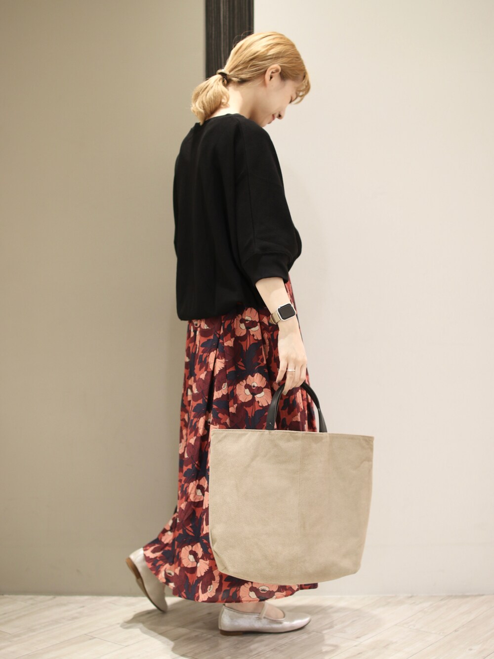 ブラック系のTシャツ/カットソー、ブラウン系のスカート、ベージュ系のトートバッグを着用したレディースの秋コーディネートの3枚目の写真