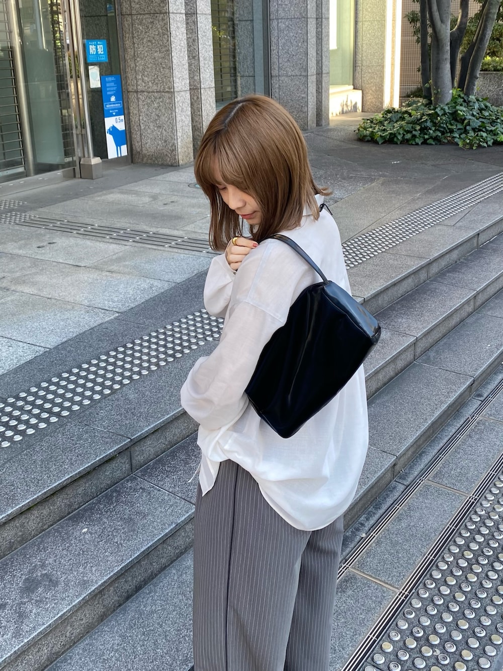 ブラック系のトートバッグ、ブラック系のローファー、グレー系のその他パンツを着用したレディースの春コーディネートの5枚目の写真