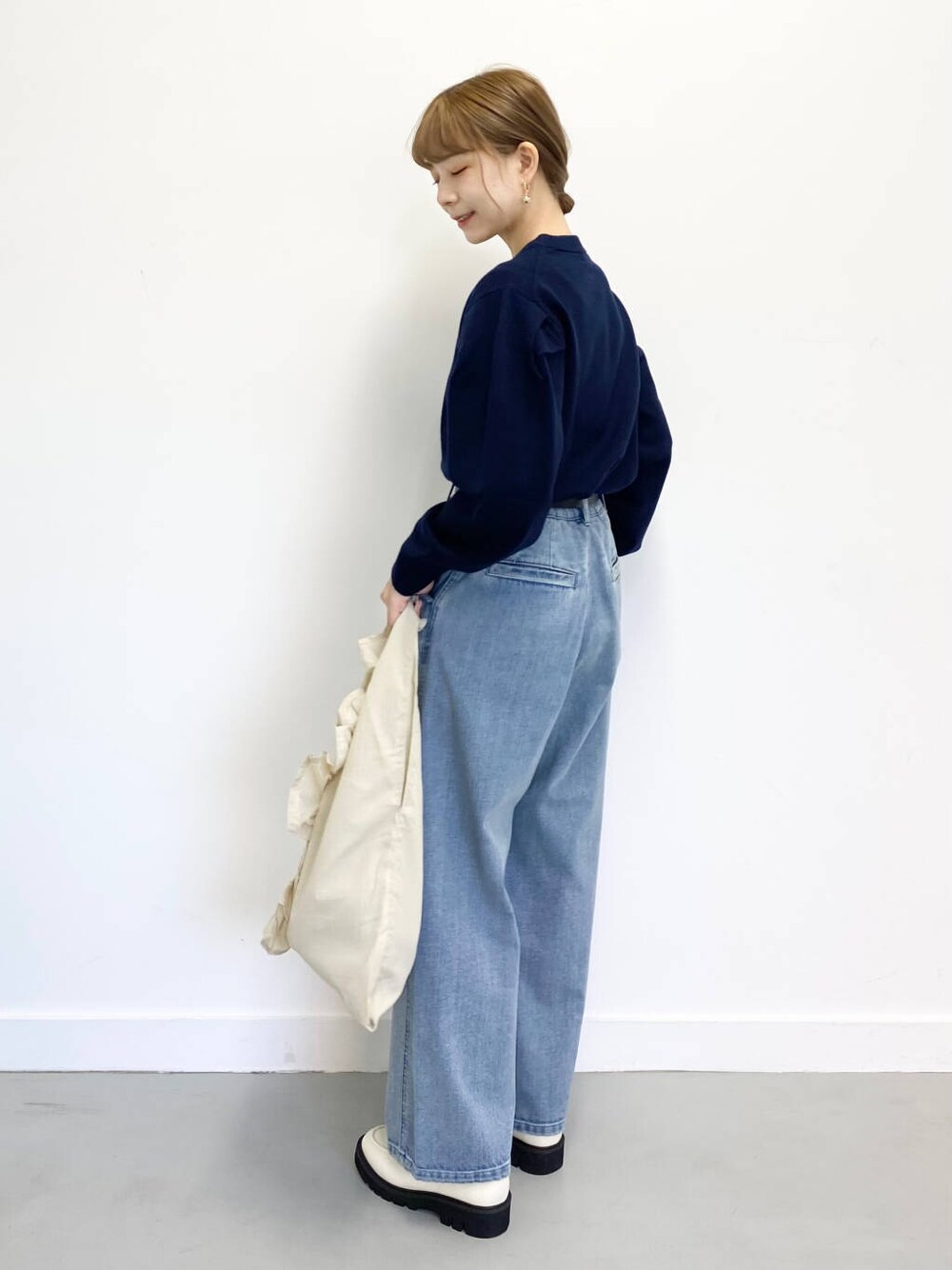 ホワイト系のローファー、ブルー系のデニムパンツ、ホワイト系のトートバッグを着用したレディースの冬コーディネートの2枚目の写真