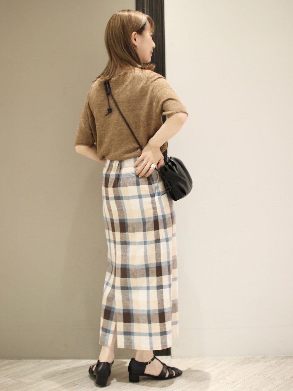 ブラック系のサンダル、ブラウン系のTシャツ/カットソー、ブルー系のスカートを着用したレディースの夏コーディネートの4枚目の写真