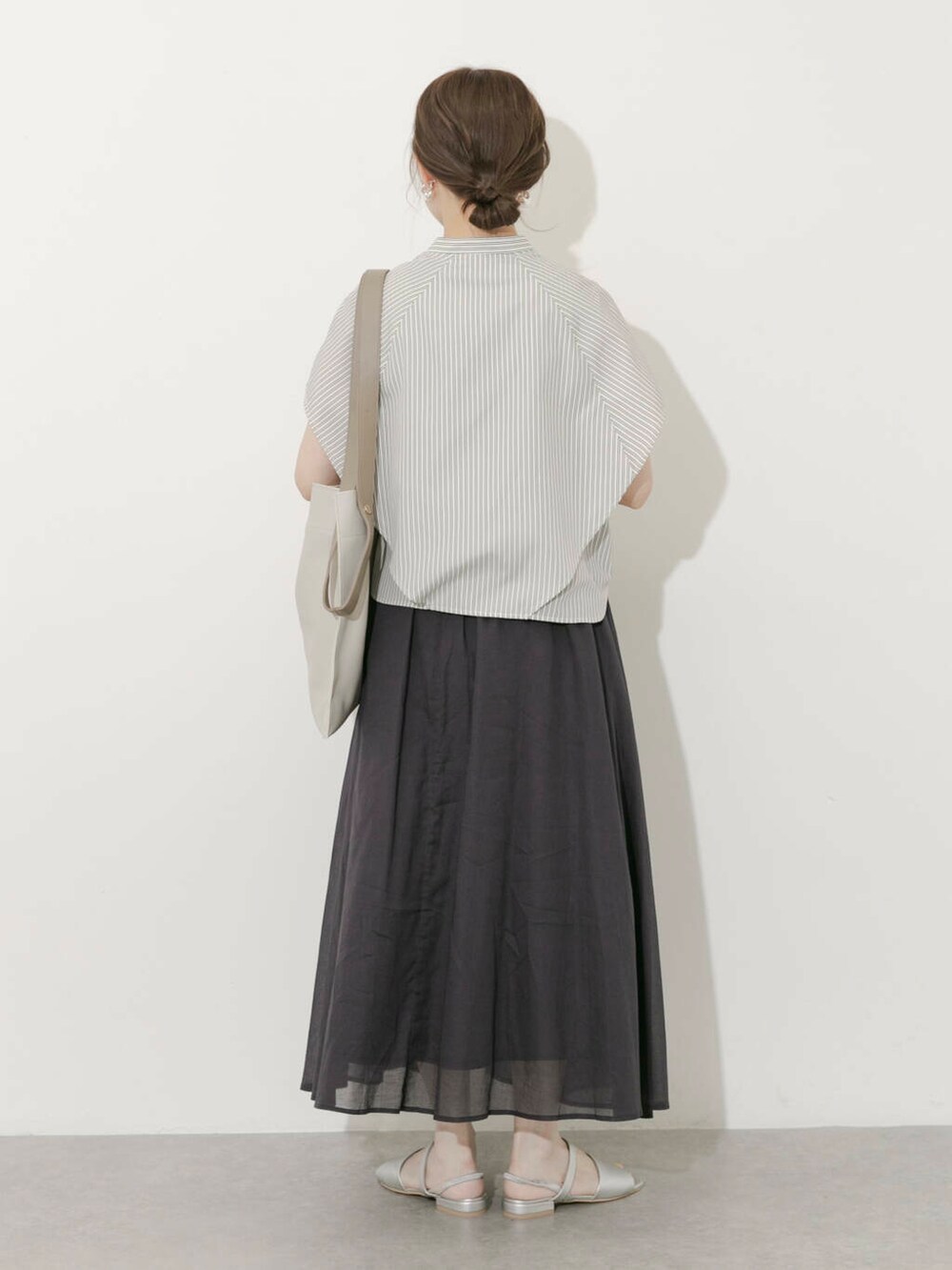 グレー系のスカート、ホワイト系のシャツ/ブラウス、シルバー系のサンダルを着用したレディースの夏コーディネートの4枚目の写真