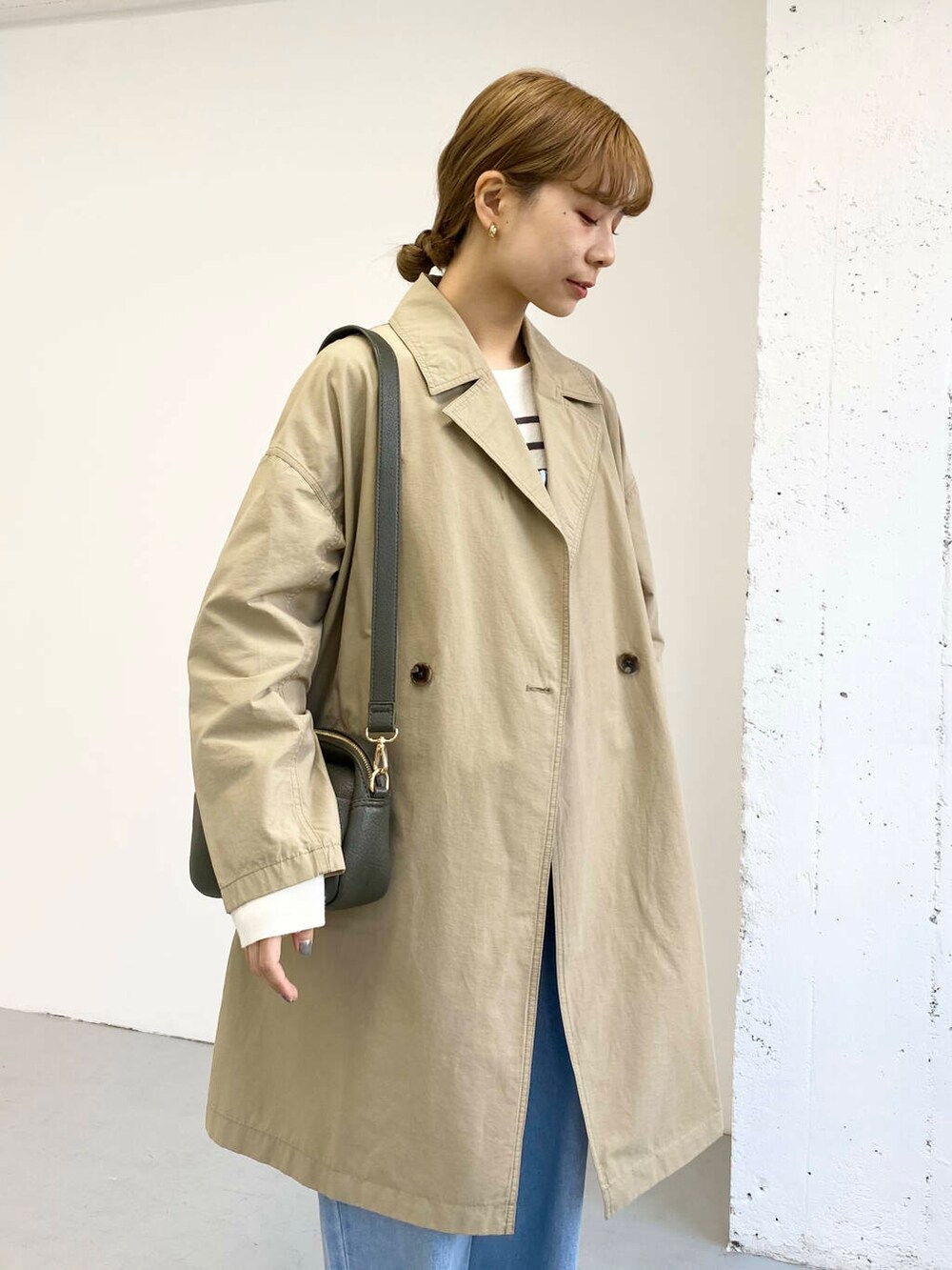 グリーン系のショルダーバッグ、ブラック系のブーツ、その他のニット/セーターを着用したレディースの冬コーディネートの2枚目の写真