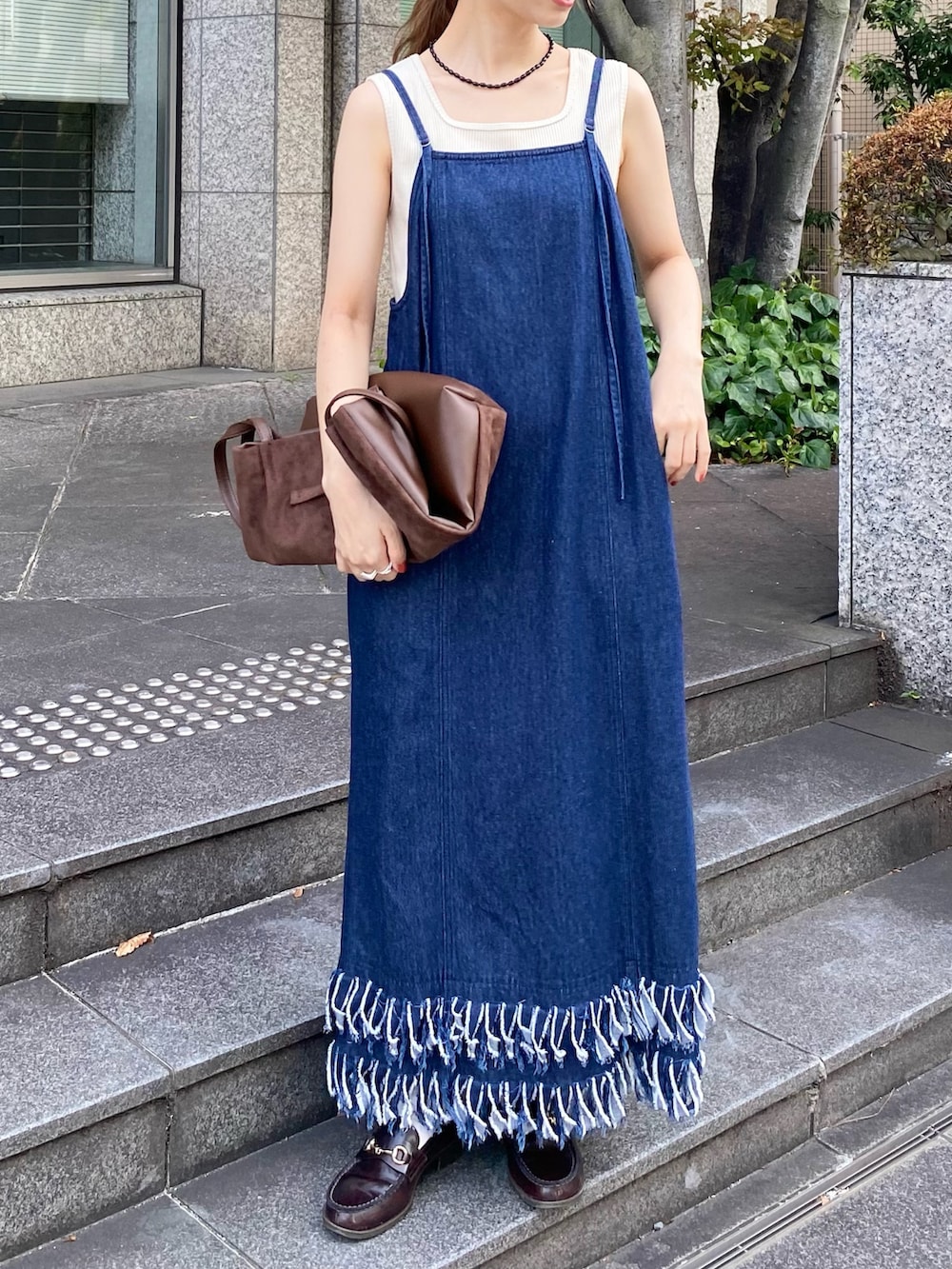 ブルー系のワンピース、ブラウン系のトートバッグ、ホワイト系のタンクトップを着用したレディースの秋コーディネートの4枚目の写真