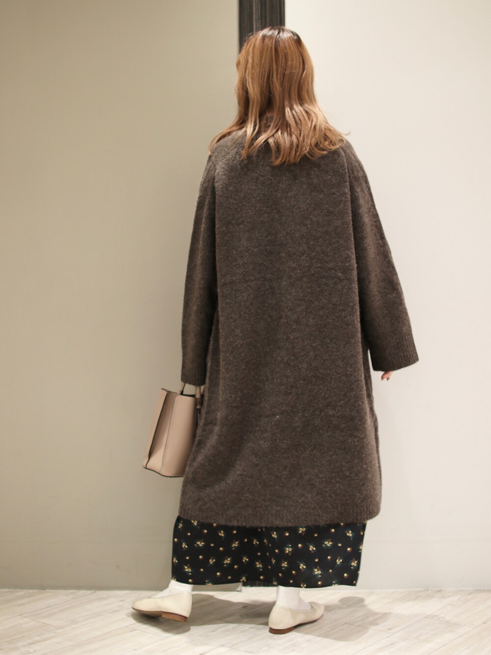 ブラウン系のトートバッグ、ブラック系のワンピース、ブラウン系のカーディガン/ボレロを着用したレディースの秋コーディネートの4枚目の写真