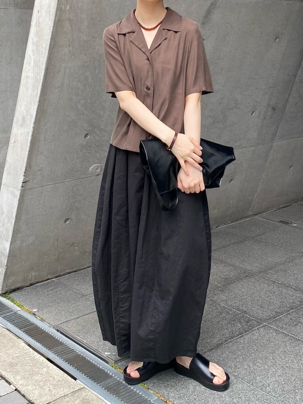 ブラック系のスカート、ブラウン系のシャツ/ブラウス、ブラック系のサンダルを着用したレディースの夏コーディネートの2枚目の写真